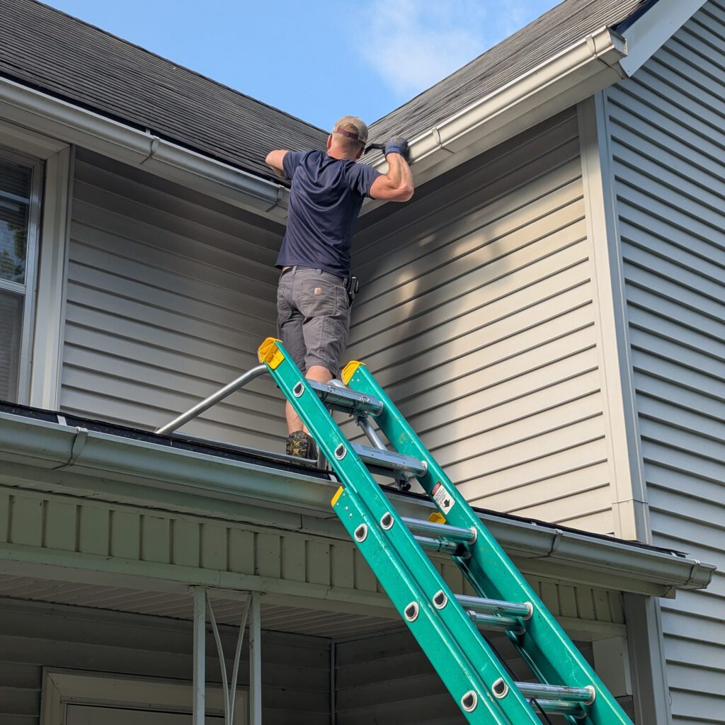 Professional gutter cleaning on a residential roof in Northeast Iowa